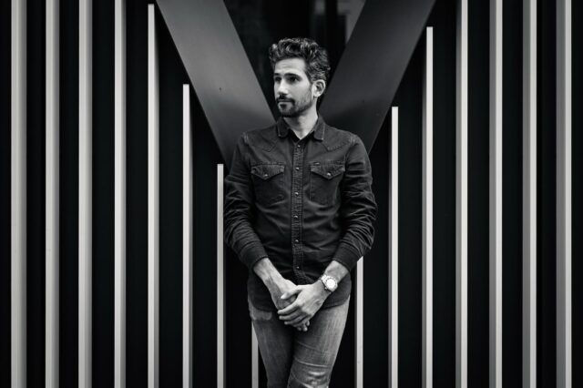 Calme, posé, les mains croisées : Christophe sait gérer. « Avec des angles comme ça, ça va claquer. » Je crois qu’il parlait du bâtiment… mais on dirait qu’il parlait de lui aussi. 😉

Montre : @holocenewatches 
#NoirEtBlanc #PortraitMinimaliste #EschBelval