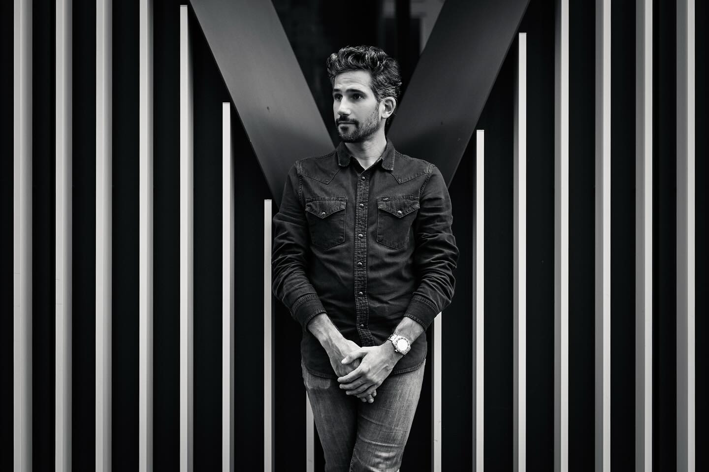 Calme, posé, les mains croisées : Christophe sait gérer. « Avec des angles comme ça, ça va claquer. » Je crois qu’il parlait du bâtiment… mais on dirait qu’il parlait de lui aussi. 😉

Montre : @holocenewatches 
#NoirEtBlanc #PortraitMinimaliste #EschBelval